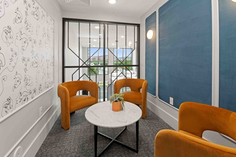 A room with a table and chairs and a wall with drawings on it.