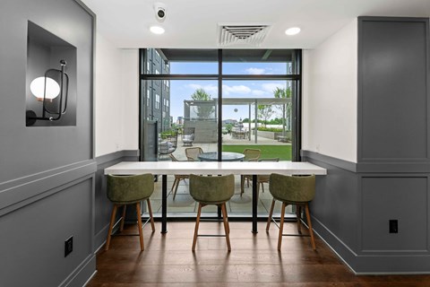 A dining room with a table and chairs with a view of the outside.