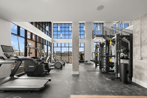 A gym with treadmills, weights, and a balcony.