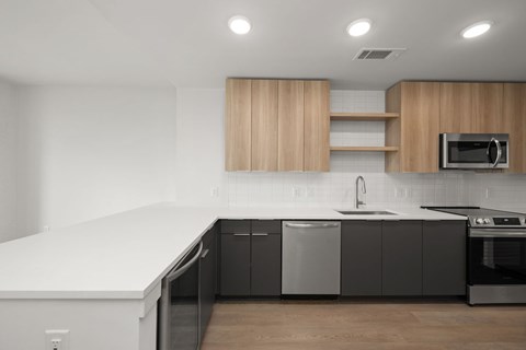 A modern kitchen with a white countertop and black cabinets.
