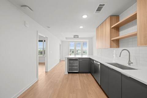 A modern kitchen with wooden cabinets and a white countertop.