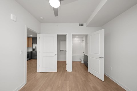 A room with white walls and wooden floors, with a white door in the center.