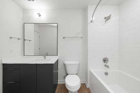 A white bathroom with a toilet, sink, and bathtub.