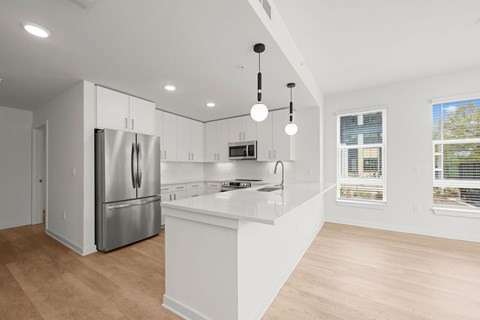 A modern kitchen with a refrigerator, cabinets, and a countertop.