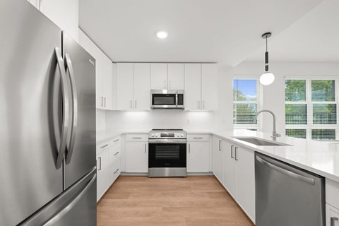 A modern kitchen with stainless steel appliances and white cabinetry.