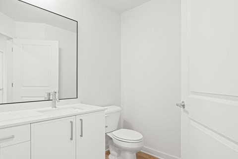 A white bathroom with a toilet, sink, and medicine cabinet.