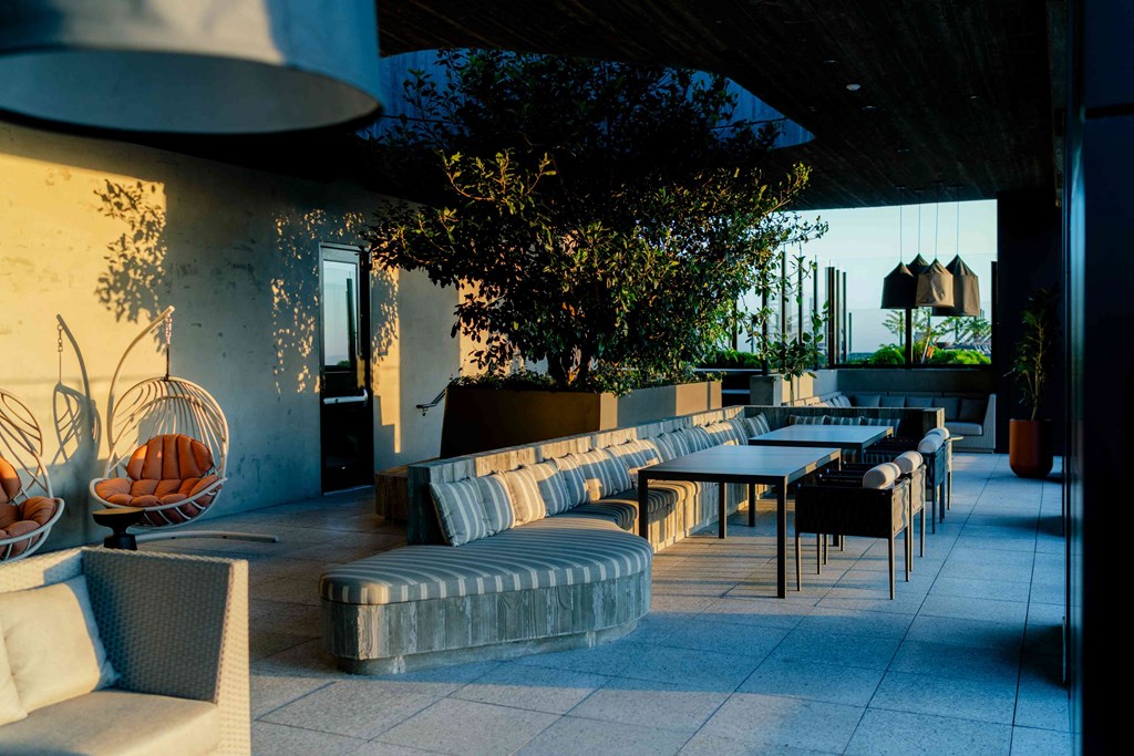 A patio with a table and chairs is bathed in sunlight.