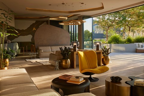 A modern living room with a yellow chair and a large rock formation.