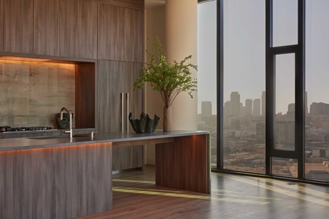 A modern kitchen with a wooden counter and a view of the city.