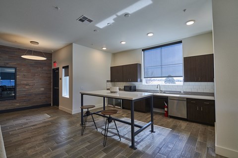 a kitchen with a island and a table with three stools