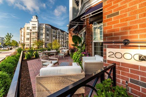 A patio with a couch and chairs is in front of a brick wall with the number 2000 on it.