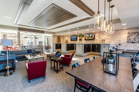 A modern living room with a wooden table and red chairs.