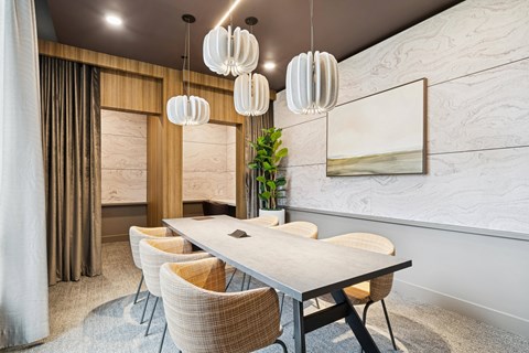 A modern dining room with a long table and chairs.