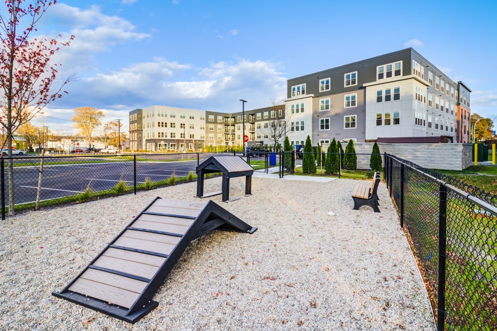 A playground with a slide and a bench in front of a building.