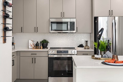 A modern kitchen with a black oven and a black microwave above it.