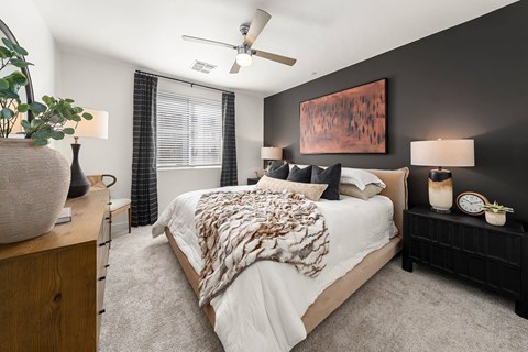 A bedroom with a large bed and a ceiling fan.