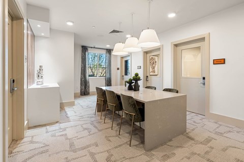 A modern dining room with a long table and chairs.