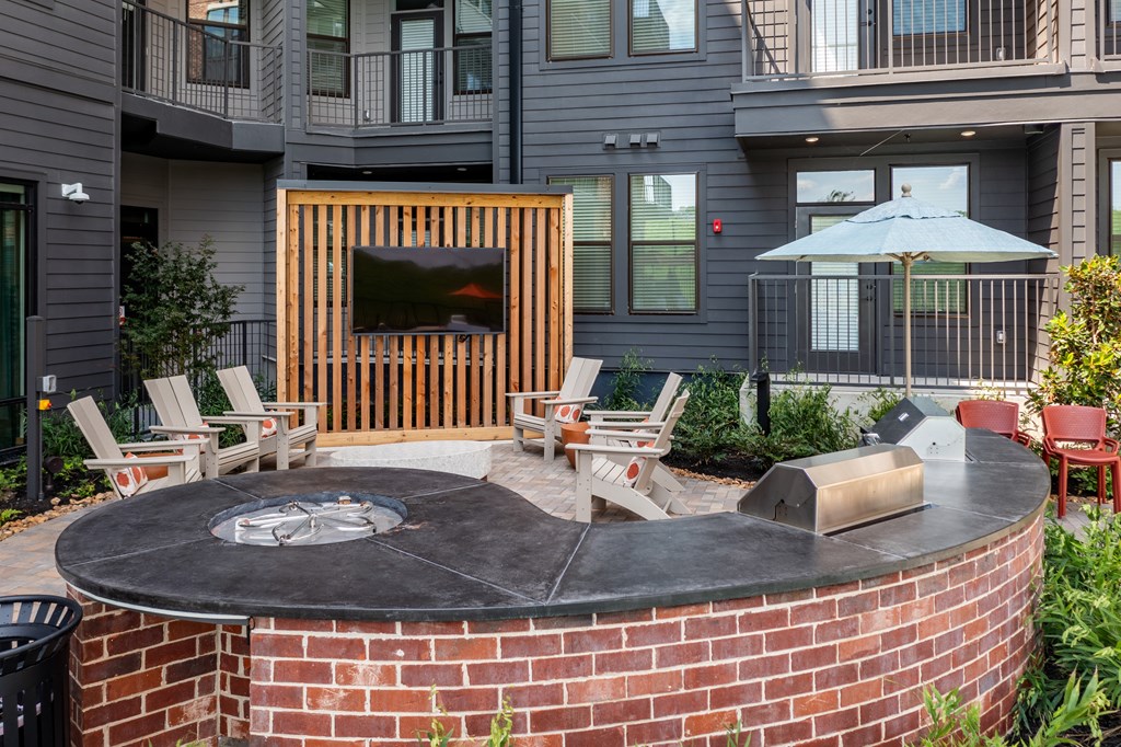 A backyard with a fire pit and chairs.