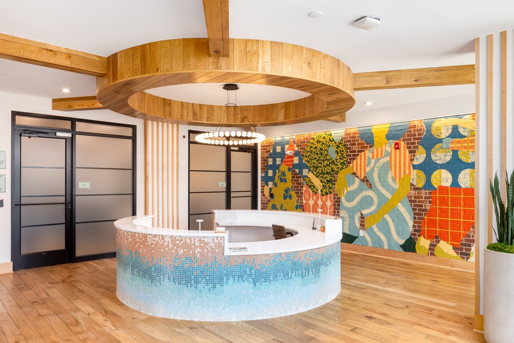 Leasing office with round leasing desk and colorful mural artwork