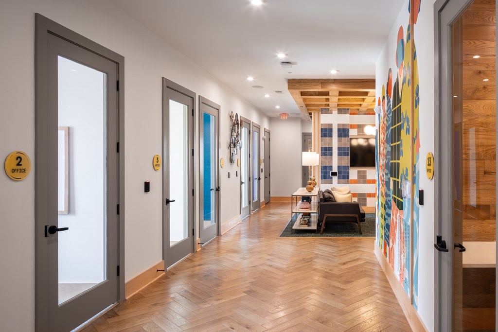 A hallway with a wooden floor and a colorful mural on the wall.