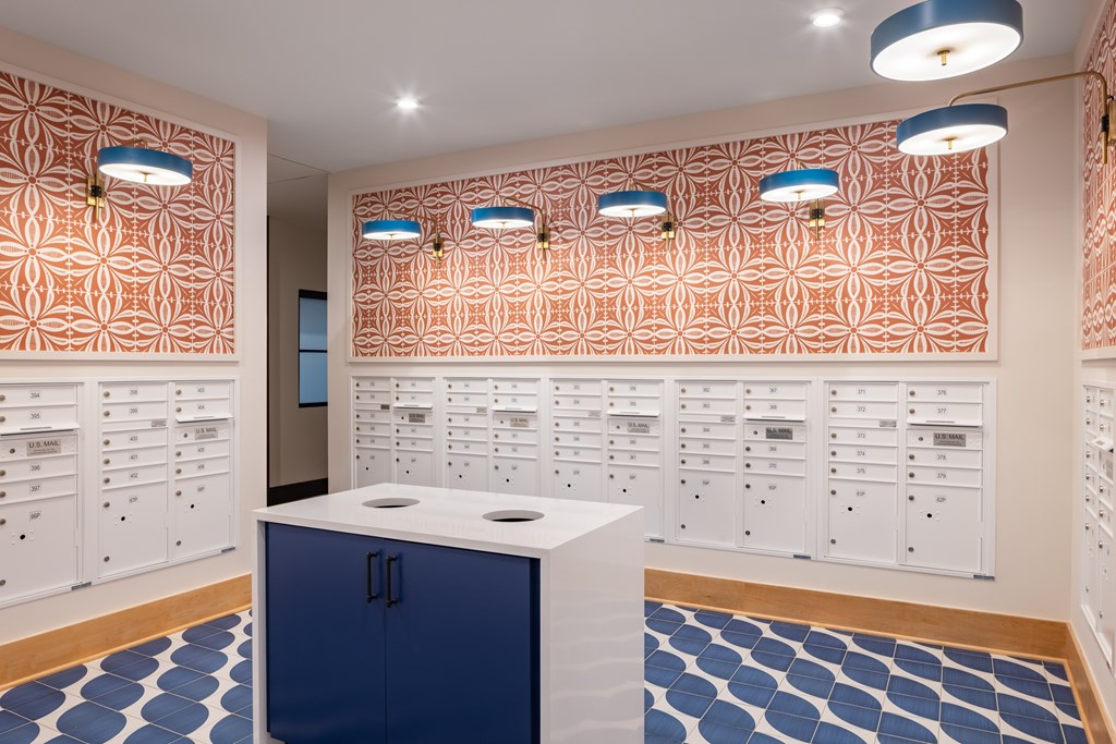 A room with a blue cabinet and a white counter in front of a wall with drawers.