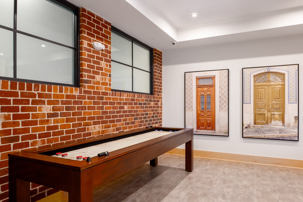 A room with a pool table and pictures on the wall.