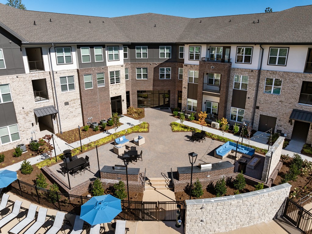 an aerial view of a courtyard with tables and umbrellas