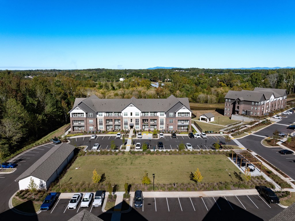 an aerial view of an apartment building and parking lot