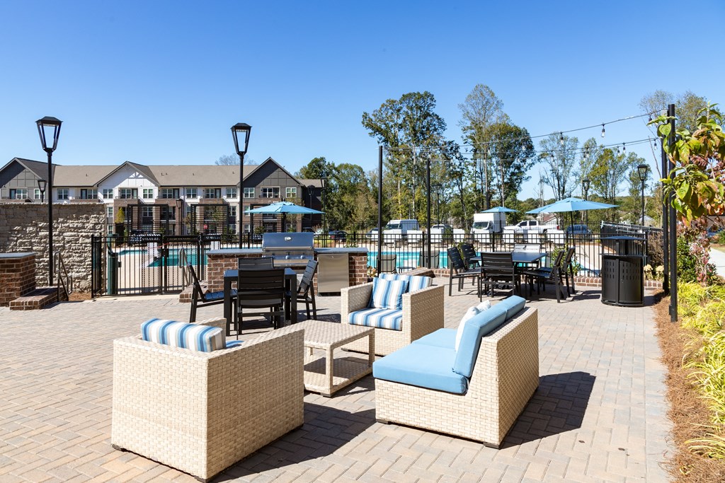 an outdoor patio with chairs and tables and a pool