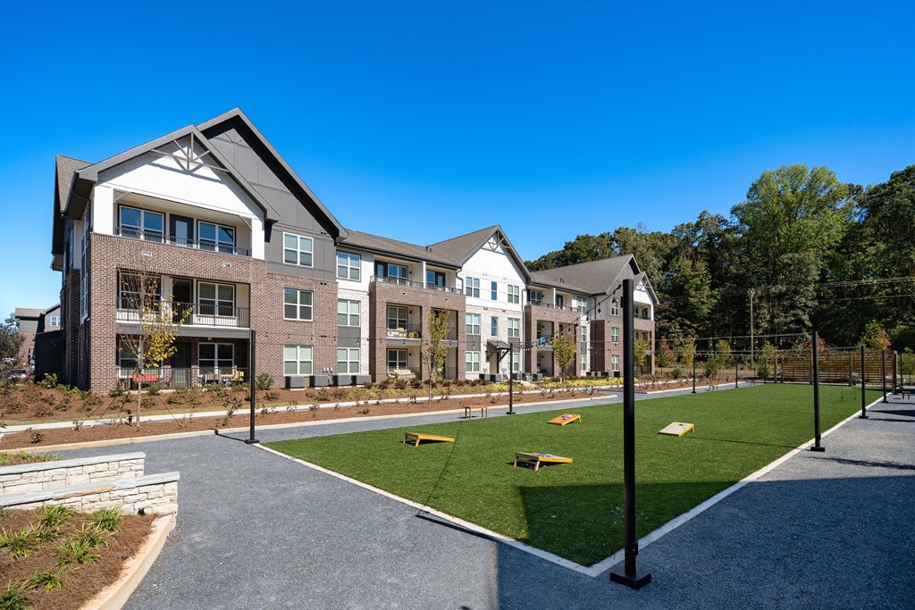 a courtyard with a tennis court in front of an apartment building