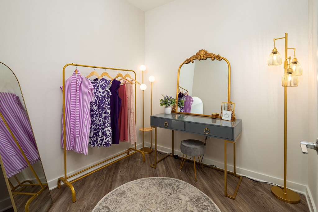 a dressing room with a black desk and a vanity with a mirror