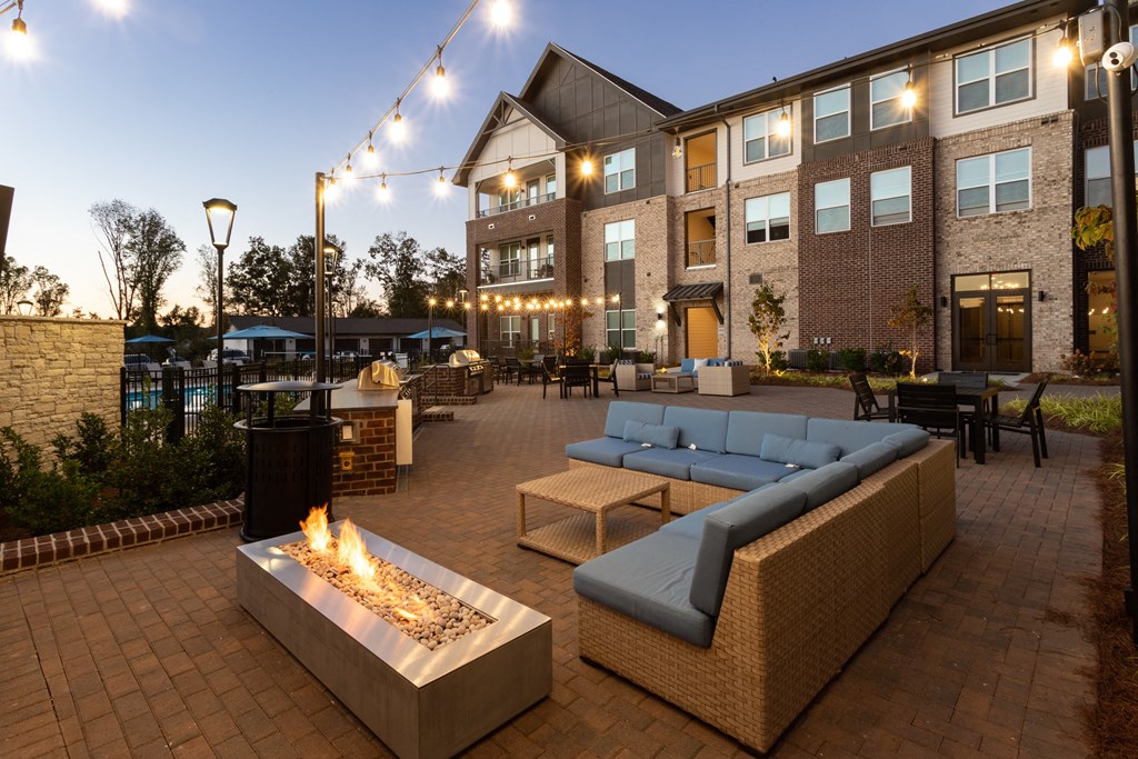 an outdoor patio with couches and tables and a fire pit