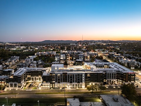 A cityscape at dusk with a large building in the foreground.