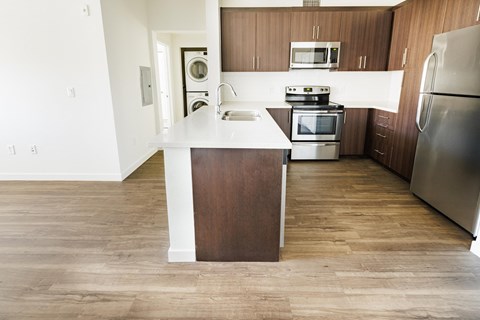 an empty kitchen with wooden cabinets and stainless steel appliances