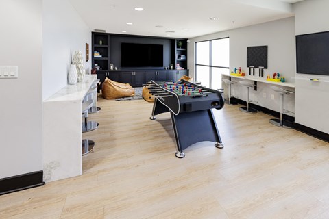 a game room with a foosball table and a tv