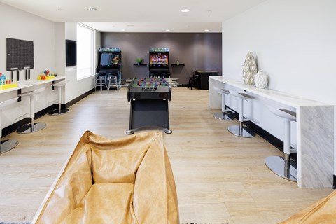 a game room with a foosball table and two televisions