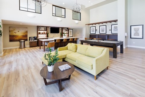 a living room with a yellow couch and a table with a pool