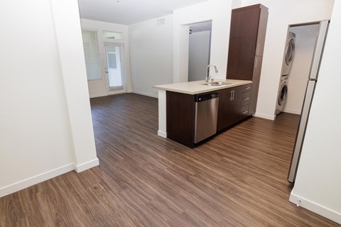 an empty bathroom with a washer and dryer in a room with wood floors