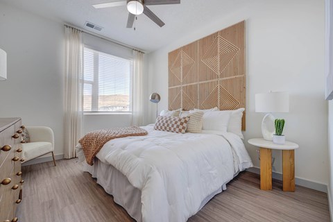 A bedroom with a large bed and a wooden headboard.