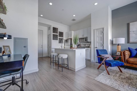 A modern kitchen with a blue chair and a white island.
