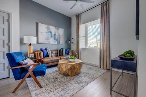 A living room with a blue chair and a wooden coffee table.