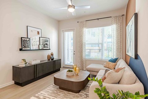A living room with a brown coffee table and a white couch.