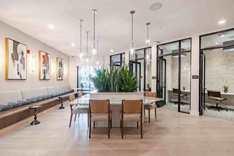 A modern dining room with a long table and chairs.
