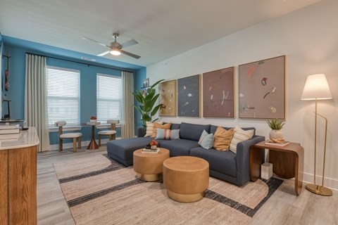 A living room with a blue couch and a wooden side table.