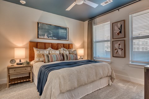 A bedroom with a large bed and a ceiling fan.