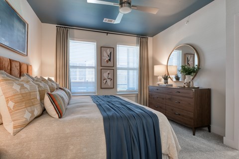 A bedroom with a large bed and a ceiling fan.