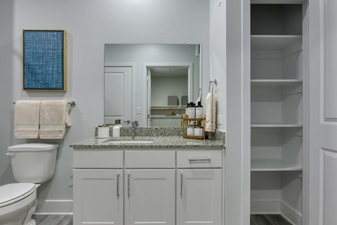 A bathroom with a toilet, sink, and medicine cabinet.