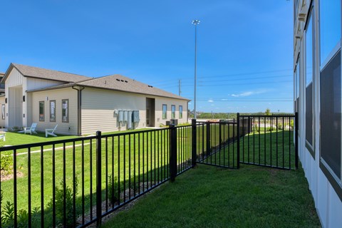 A black metal fence surrounds a green lawn.