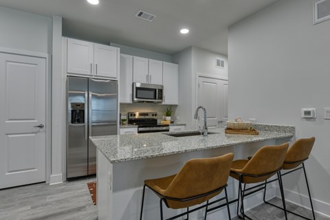 A kitchen with a granite countertop and stainless steel appliances.