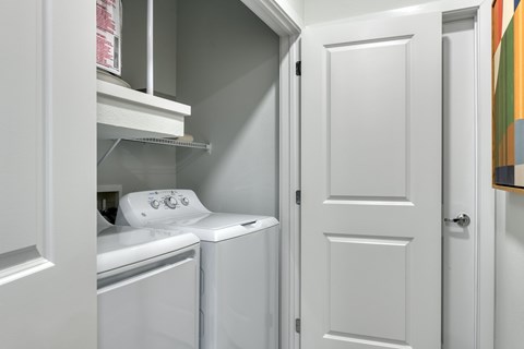 A white laundry room with a washer and dryer.